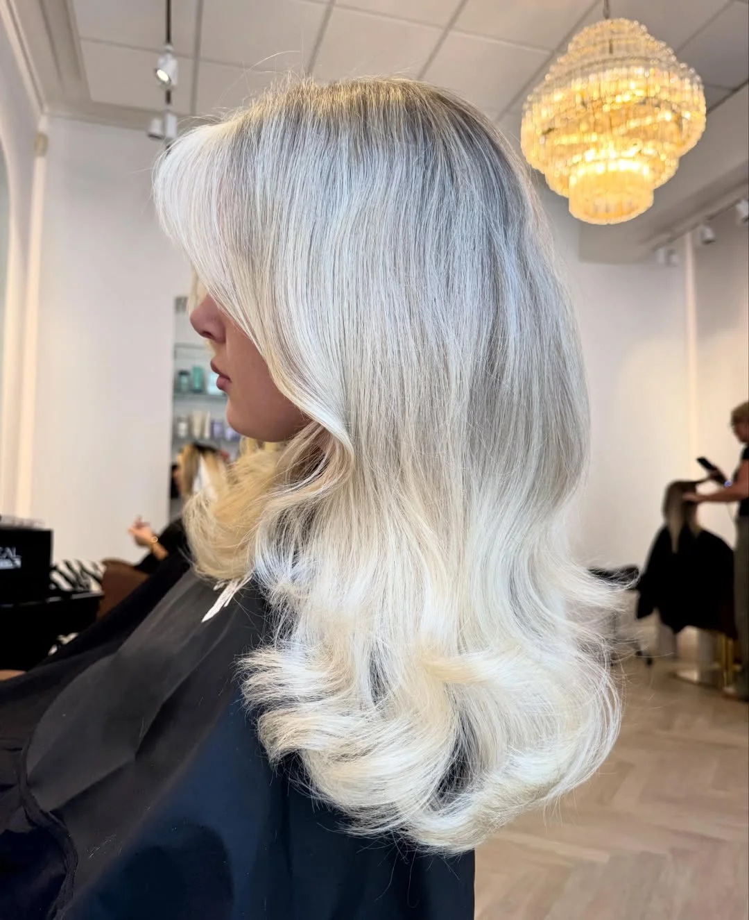 beachy summer blonde hair color 2026 Feathered Ice Blonde Layers With Vintage Blowout Movement