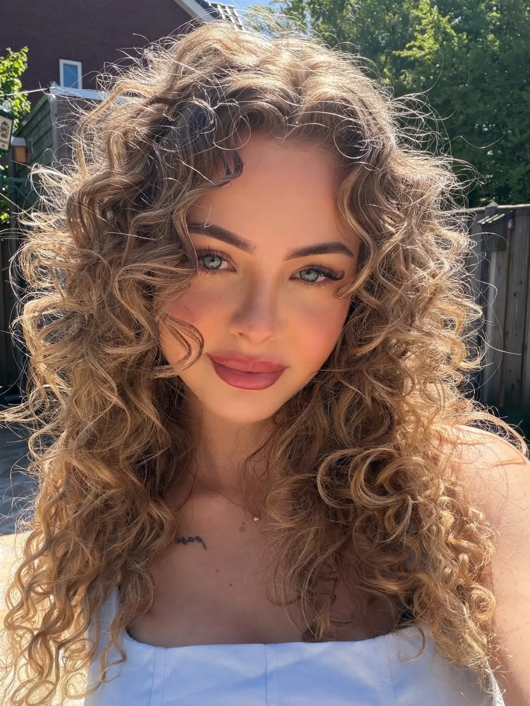 trendy summer hair color ideas 2026 Muted Caramel Curls With Voluminous Retro Energy