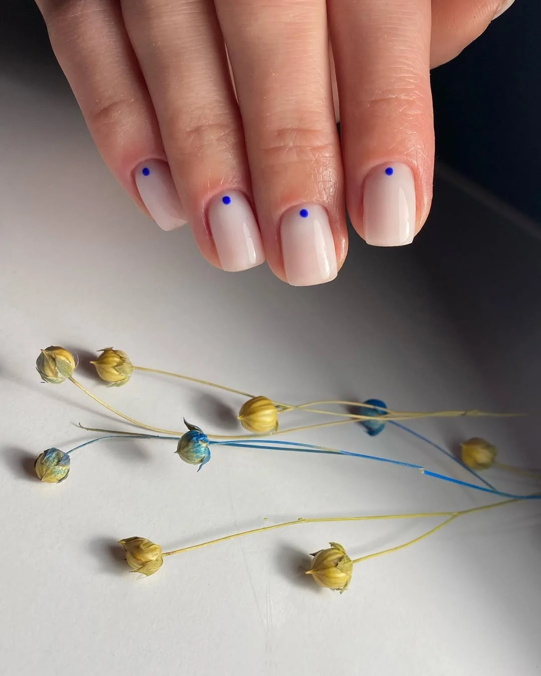 21 short summer nails 2026 Minimal Nude Nails With Tiny Blue Dot Accents