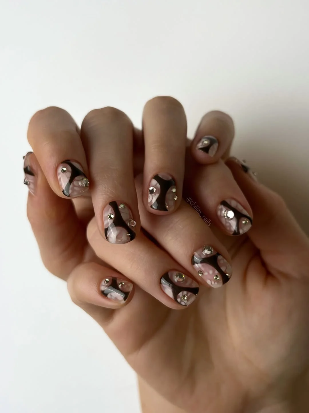 21 short summer nails 2026 Abstract Black Swirl Nails With Crystal Details