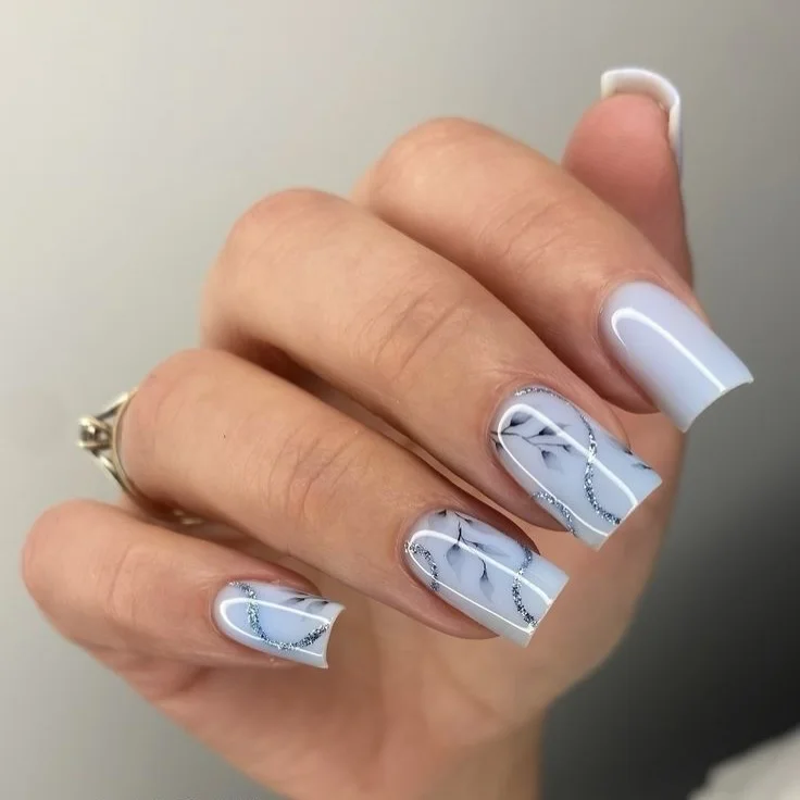 21 summer manicure color ideas 2026 Soft Marble Blue Nails With Silver Glitter Waves