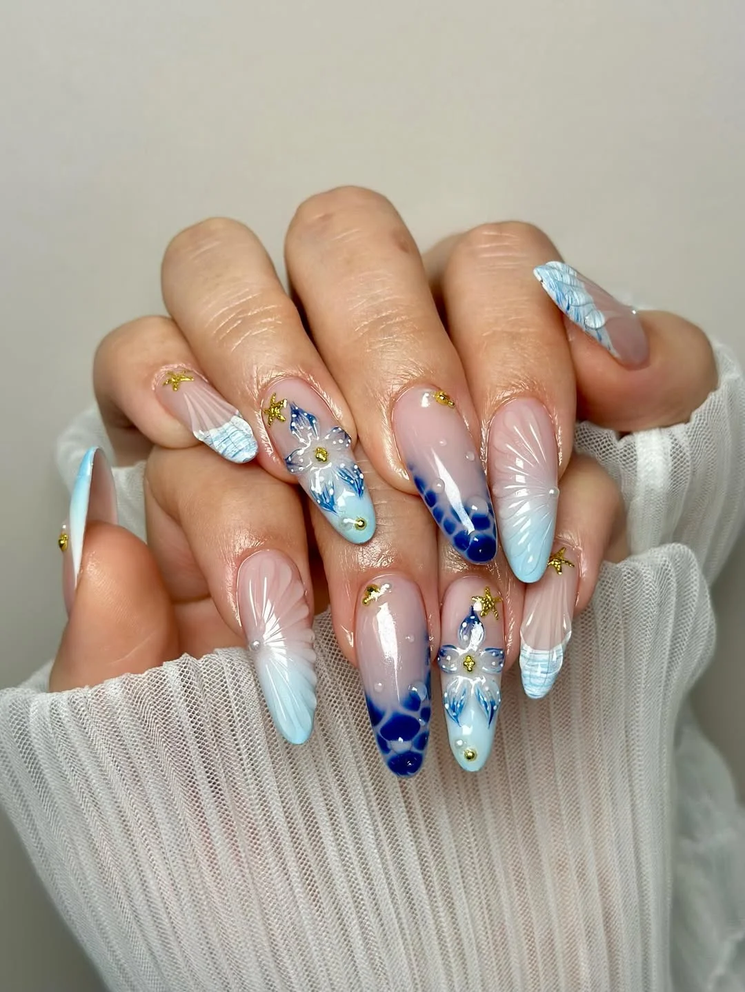 23 Summer nail art ideas 2026 Coastal Shell Nails With Soft Ocean Blue Details